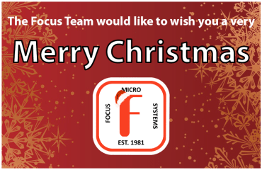 A graphic with a red background with snowflakes, wishing the reader a Merry Christmas. It also features a logo of a Red 'F' surrounded by the words 'Focus Micro Systems Est. 1981', with a Santa hat on the F.